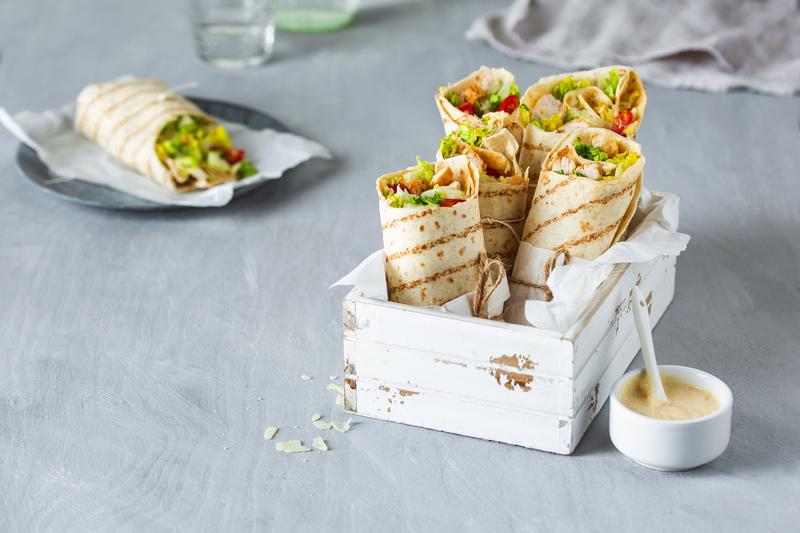 Weiße Holzbox mit vier aufgestellten Caesar Salad Wraps aus dem Thermomix®