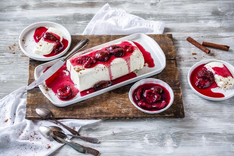 Vanilleparfait mit Glühweinkompott auf Holzbrett