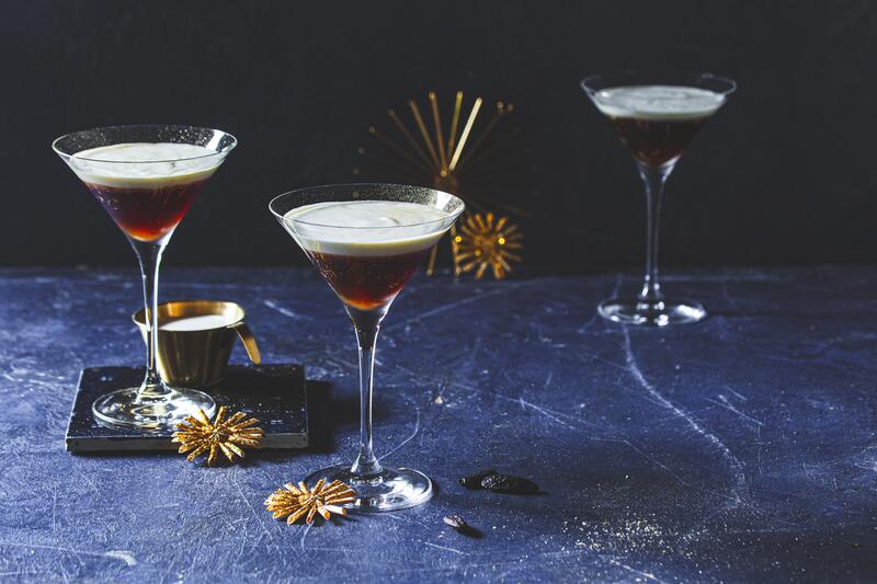 Zwei Martini-Gläser mit White Russian auf dunkelblauem Untergrund