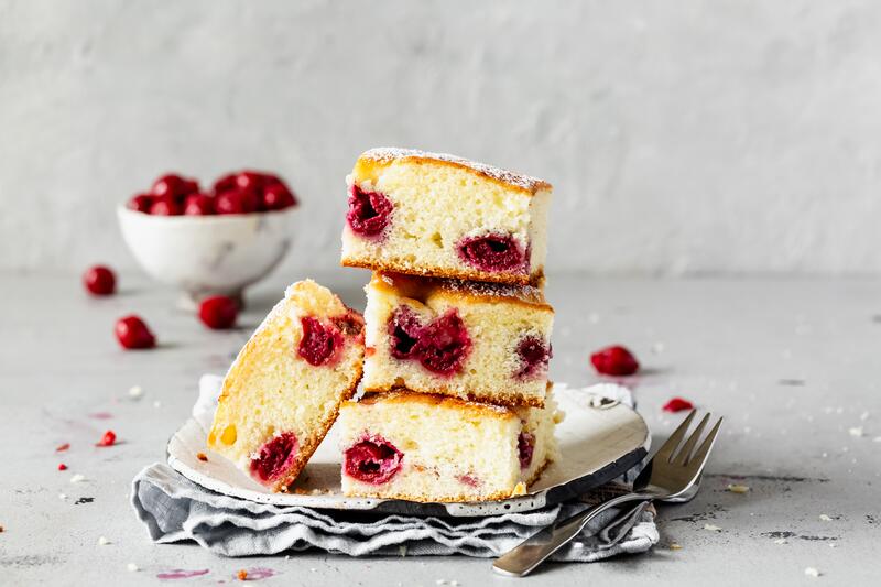 Saftiger Kirschkuchen vom Blech in Stücke geschnitten aufeinander gestapelt