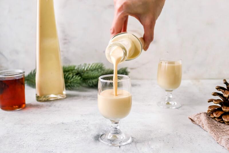 Engelchenlikör in Schnapsgläsern auf Holzuntergrund