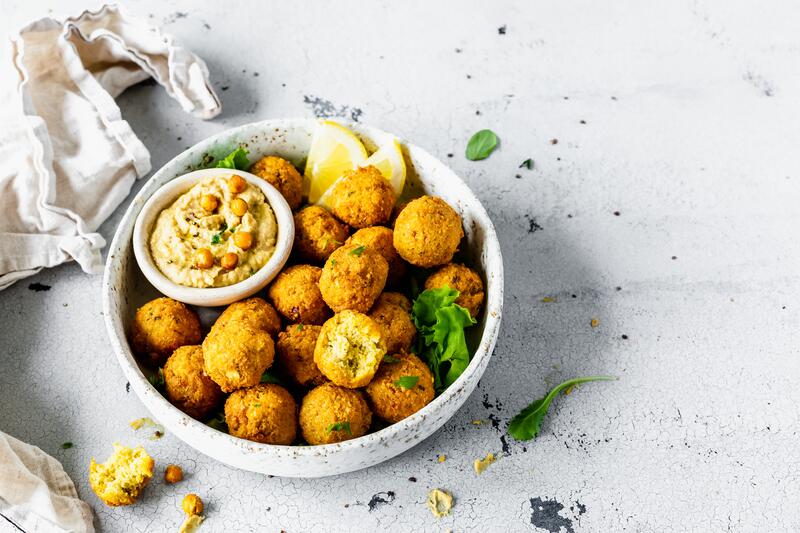 Weißer Teller mit Falafel und Dip in Schälchen