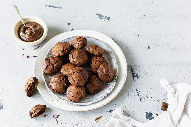 Dose mit Nutella-Plätzchen auf grauem Untergrund