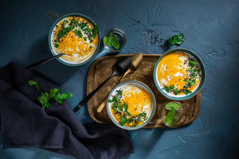 Vegane Kürbis-Linsen-Suppe mit Kokosmilch auf dunklem Hintergrund