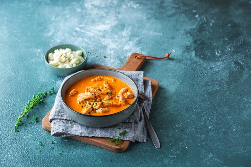 Schale Blumenkohlreis und Schale mit Putengulasch in roter Sauce