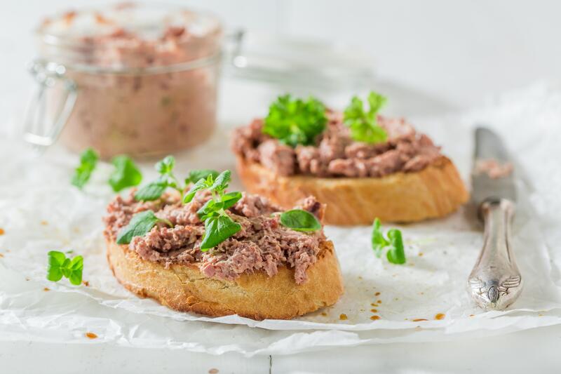 Vegane Leberwurst auf Baguette-Brot mit Basilikum garniert