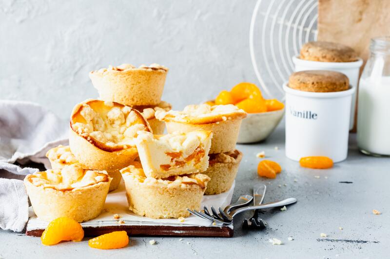 Mehrere Käsekuchenmuffins mit Mandarinen
