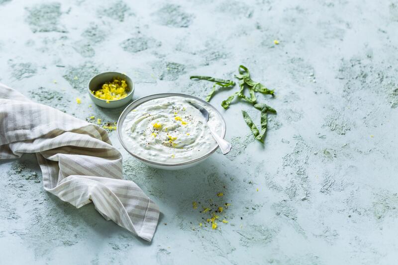 Schale mit Bärlauchquark auf marmoriertem Untergrund