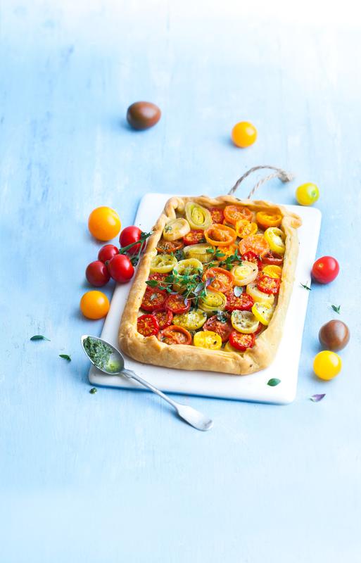 Tomatenkuchen mit Kräutertopping auf Brett.