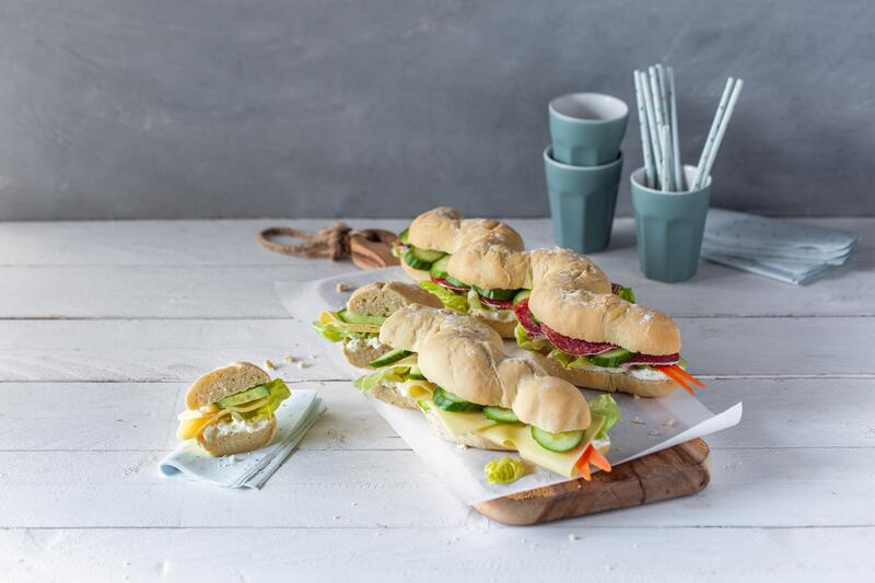 Zwei belegte Schlangen-Sandwiches auf Holzbrett