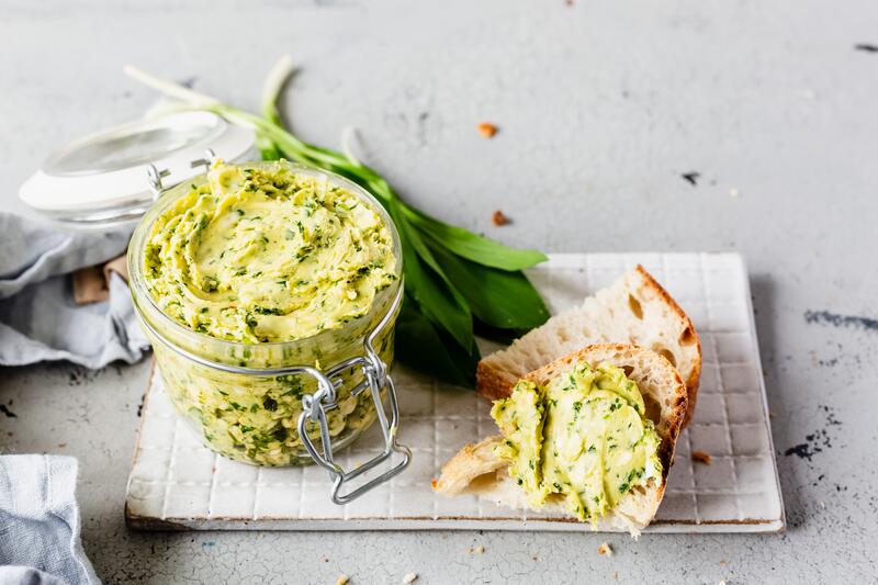 Verschließbares Glas mit Bärlauchbutter mit angelegtem Baguette