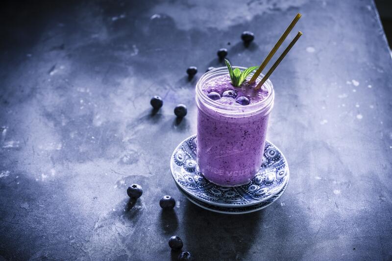 Blaubeershake mit Joghurt auf dunklem Grund mit Heidelbeeren