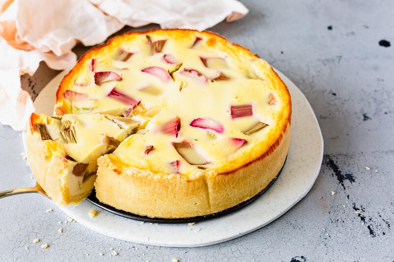Angeschnittener Rhabarberkuchen mit Schmand aus der Springform