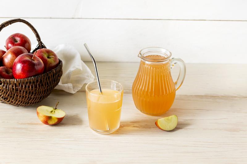 Ein Glas und eine Karaffe mit Apfelsaft