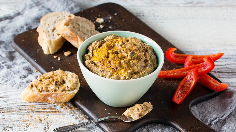 Hellblaues Schälchen mit Pflaumendip, daneben Brot und Paprika