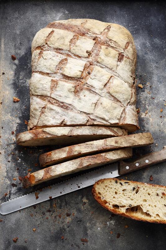 Angeschnittenes Landbrot mit angelegtem Brotmesser von oben