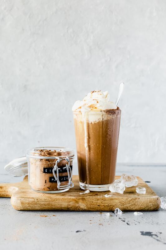ein Glas mit Eiskaffee vor hellem Hintergrund
