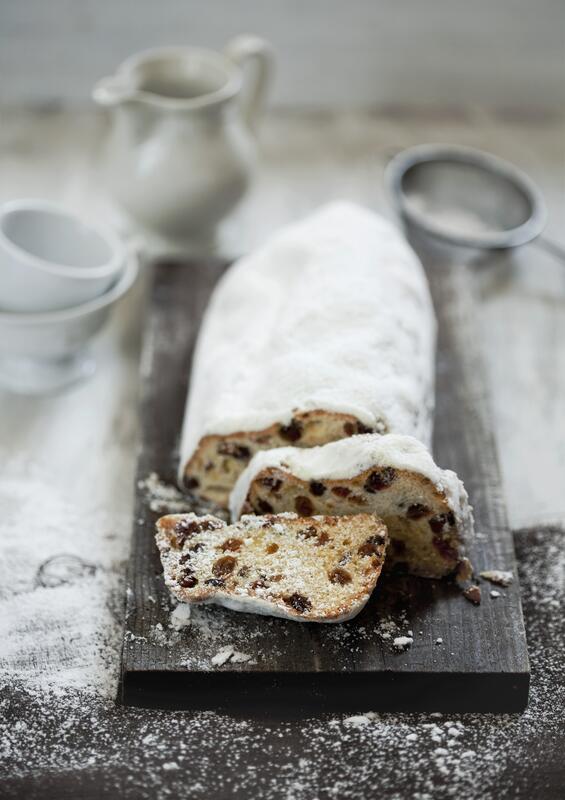 Angeschnittener Christstollen auf dunklem Bett