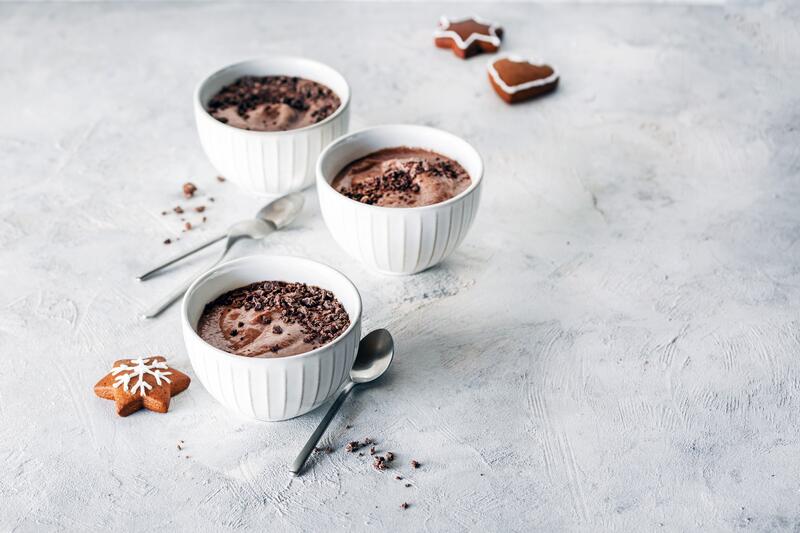 Drei weiße Schälchen mit Lebkuchen-Mousse auf hellem Untergrund