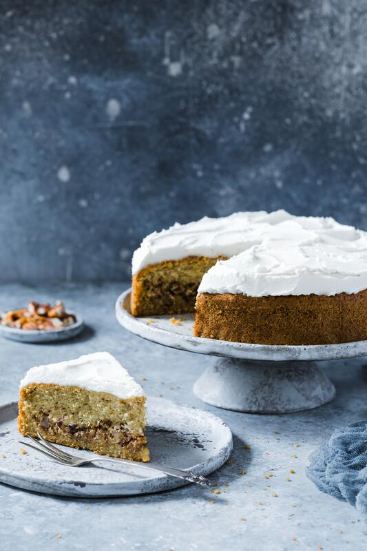 Stück Pekannusskuchen mit White Chocolate Frosting auf Kuchenteller