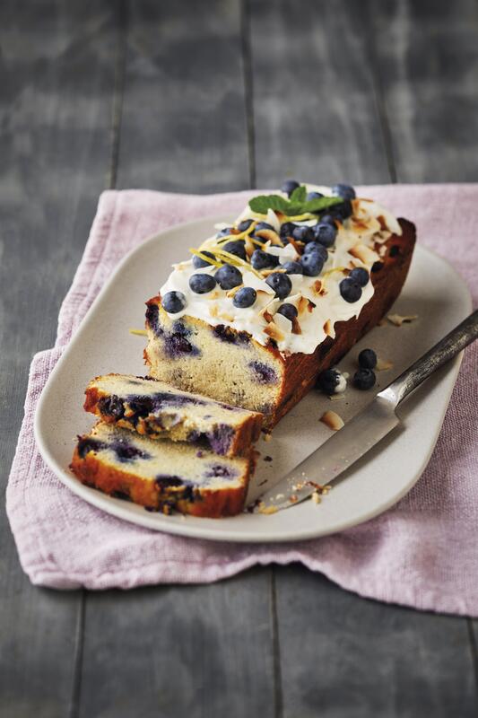 Kuchen mit Beeren auf einem Teller und rosa Tischdecke