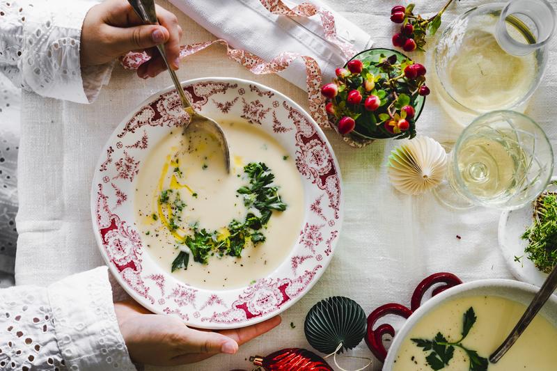 Suppe in rot weißem Suppenteller mit Blumen und Wasserglas