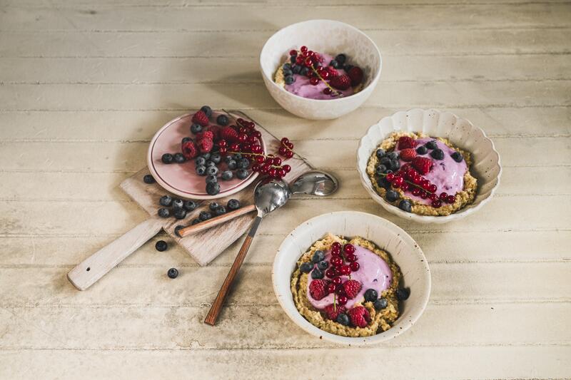 Rosa Joghurt mit frischen Beeren in Schalen
