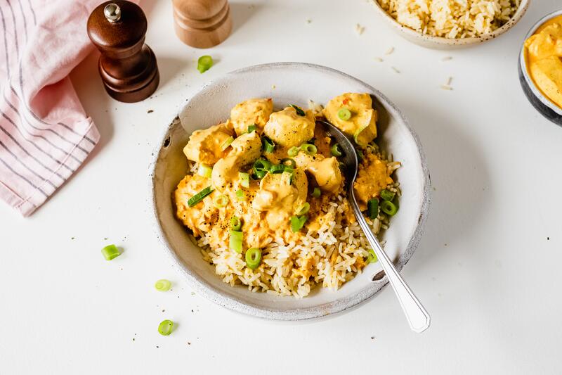 Hähnchen mit Curry-Schmand-Soße in tiefem Teller