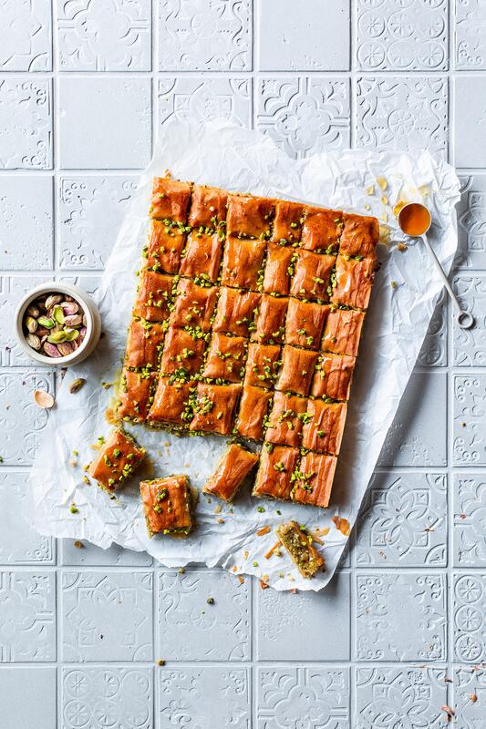 Baklava in Stücke geschnitten auf einem Stück Backpapier.