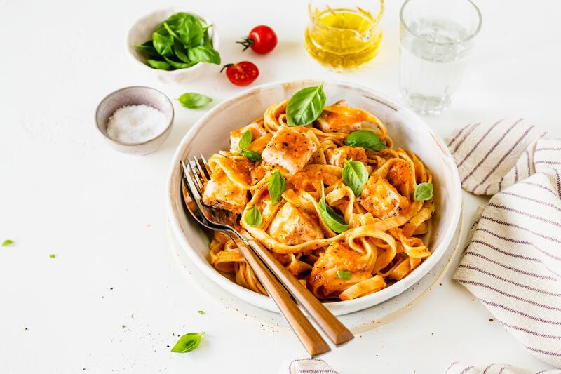 Tomaten-Lachs-Nudeln in tiefem weißen Teller