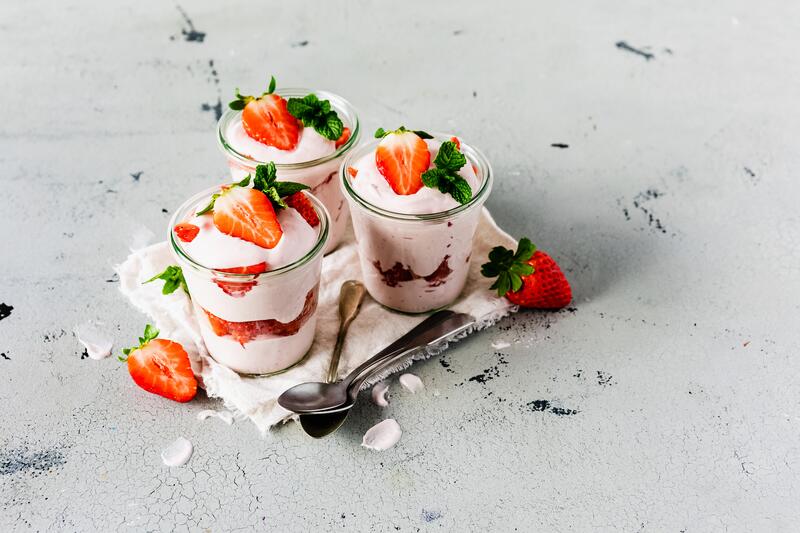 3 Gläser mit Erdbeerquark und frische Erdbeeren getoppt