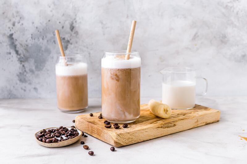 Zwei Gläser mit Frozen Banana Latte mit angelegter Banane