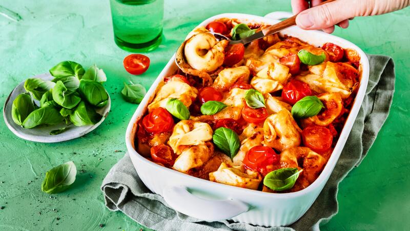 Weiße Auflaufform mit Tortellini in Tomatensoße