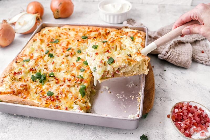 Angeschnittener Zwiebelkuchen auf Blech