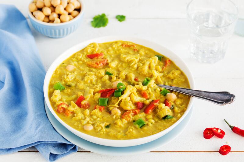 Blumenkohlcurry mit Kichererbsen in tiefem weißen Teller