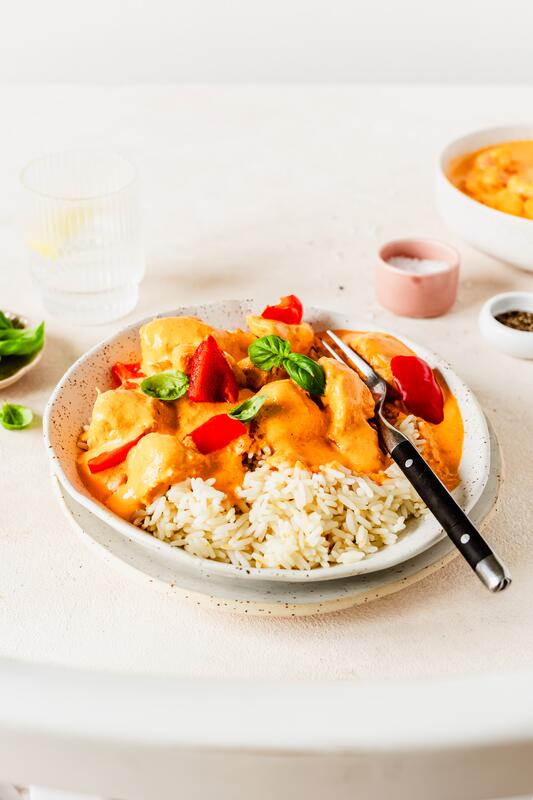 Weißer Teller mit Hähnchenwürfel mit Paprika-Schmand-Soße