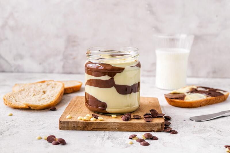 Kuhflecken-Aufstrich in Glas auf Holzbrett