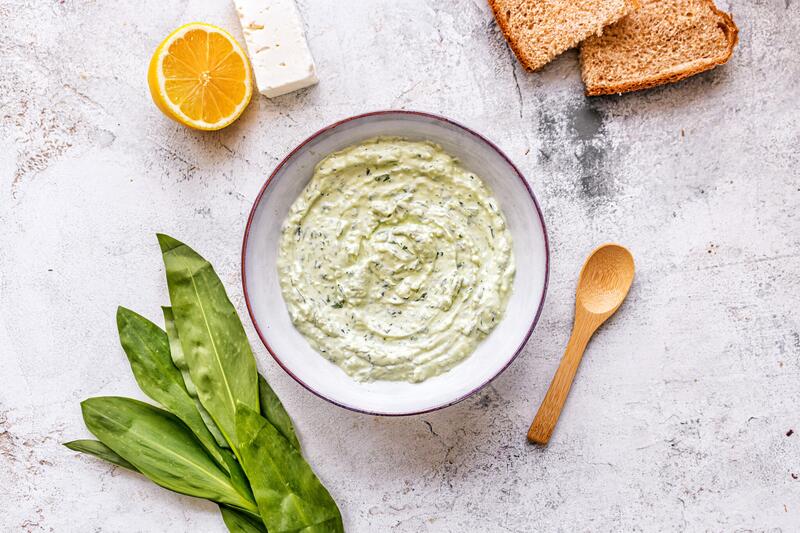 Bärlauch-Dip in kleiner Schüssel mit angelegten Bärlauchblättern