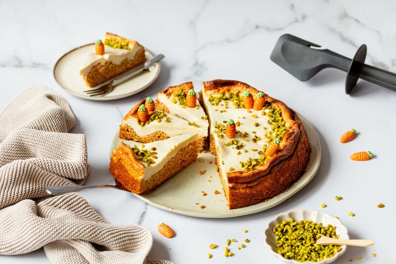 Angeschnittener Karotten-Käsekuchen aus der Springform mit Marzipan-Möhren