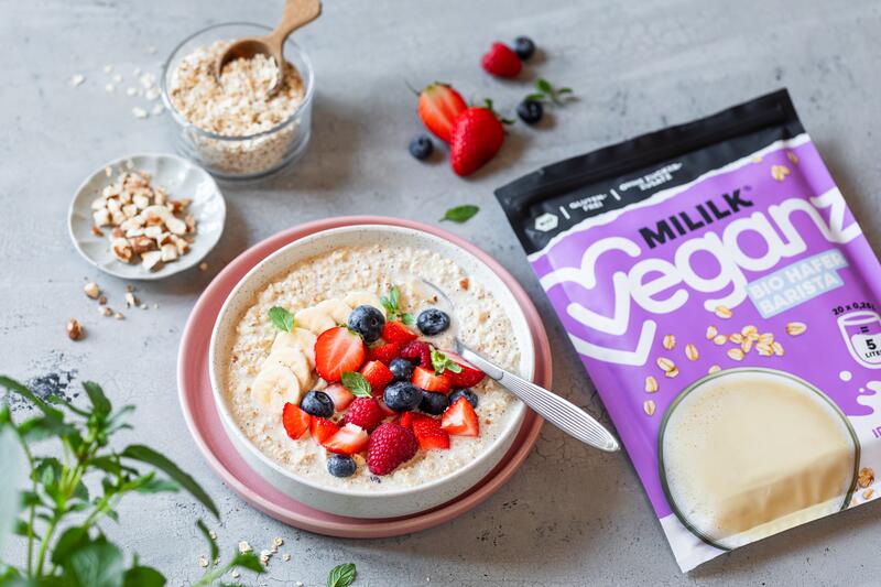 Bircher Müsli in Schüssel mit Beeren mit angelegter Bio Veganz Mililk® Hafer Barista