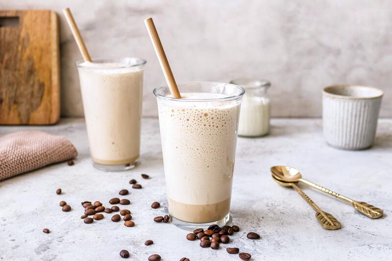 Geeistes Kaffee-Wölkchen in zwei großen Gläsern mit Strohhalm