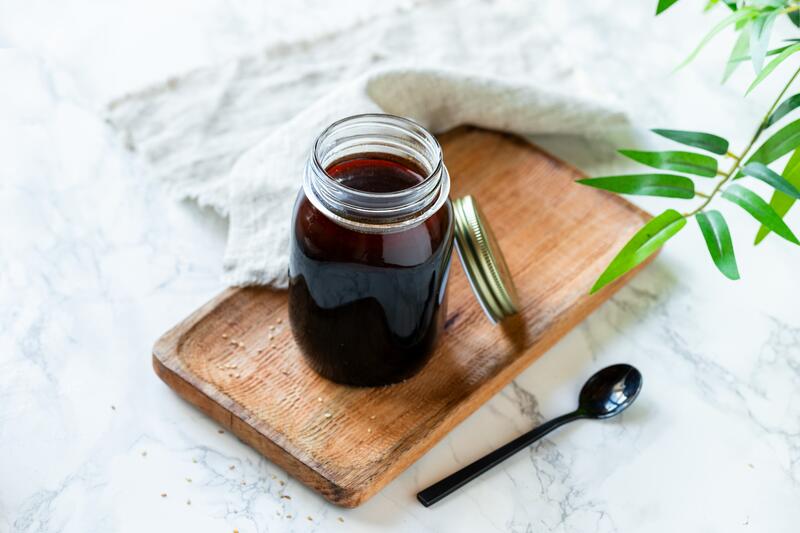 Einfache Teriyakisoße in verschließbarem Glas auf Holzbrett