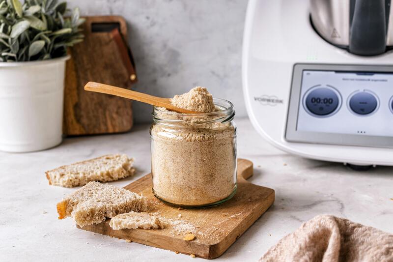 Paniermehl in verschließbarem Glas auf Holzbrett vor Thermomix®