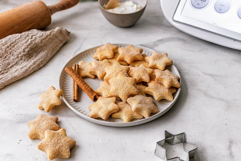 Ein Teller mit sternförmigen Plätzchen, daneben der Thermomix®