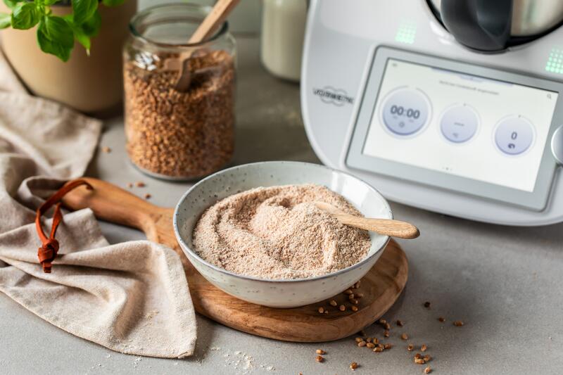 Vollkornmehl fertig gemahlen in einer Schüssel, dahinter steht der Thermomix®
