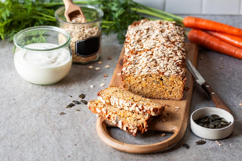 Aufgeschnittenes Brot mit Haferflocken auf einem Holzbrett
