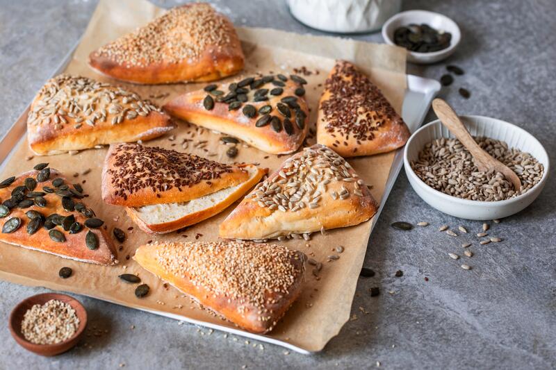 Holzbrett mit verschiedenen Körnerbrötchen