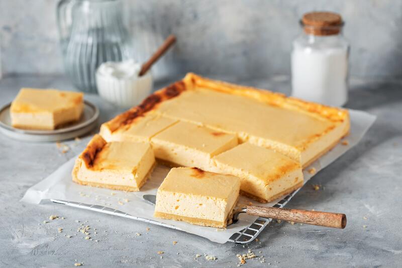 Käsekuchen auf einem Backblech in Quadrate geschnitten