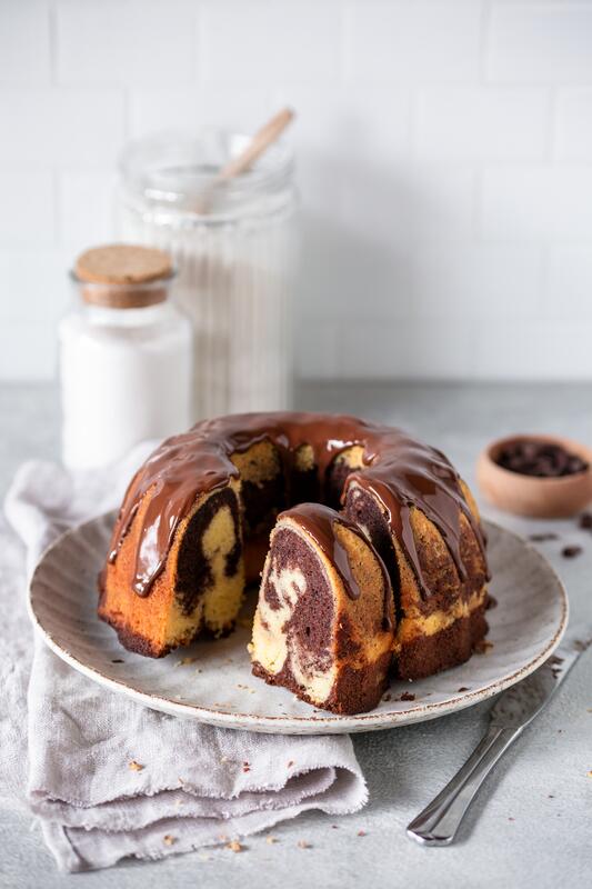 Teller mit angeschnittenem Gugelhupfkuchen mit Marmorierung