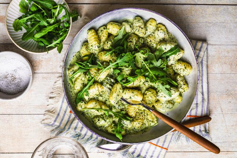 Teller mit Gnocchi in grüner Sahnesoße mitt Ruccola getoppt